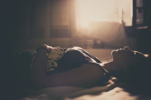 Sad girl lying in bed